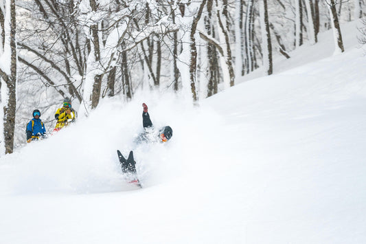 Snowboarder riding the Weston Japow throwing a nose butter in deep Japanese powder