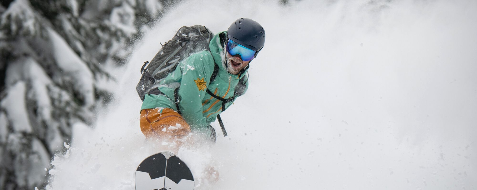 backcountry splitboard guide riding deep powder and smiling in revelstoke