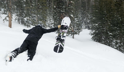 Splitboarder jumping into deep snow with the weston backwoods carbon splitboard in a snowy forest