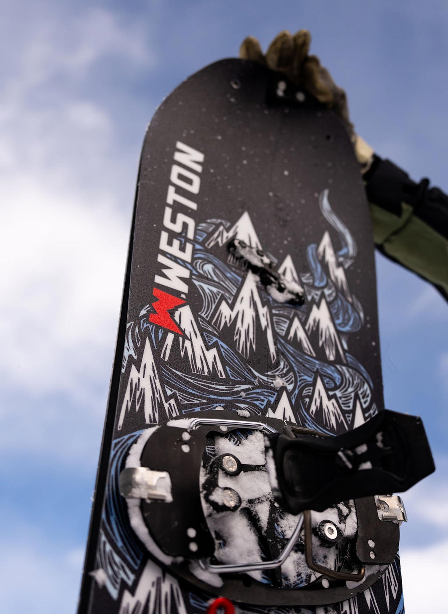 Weston Dream Machine Splitboard with mountain design in the art style of John Fellows against a cloudy sky