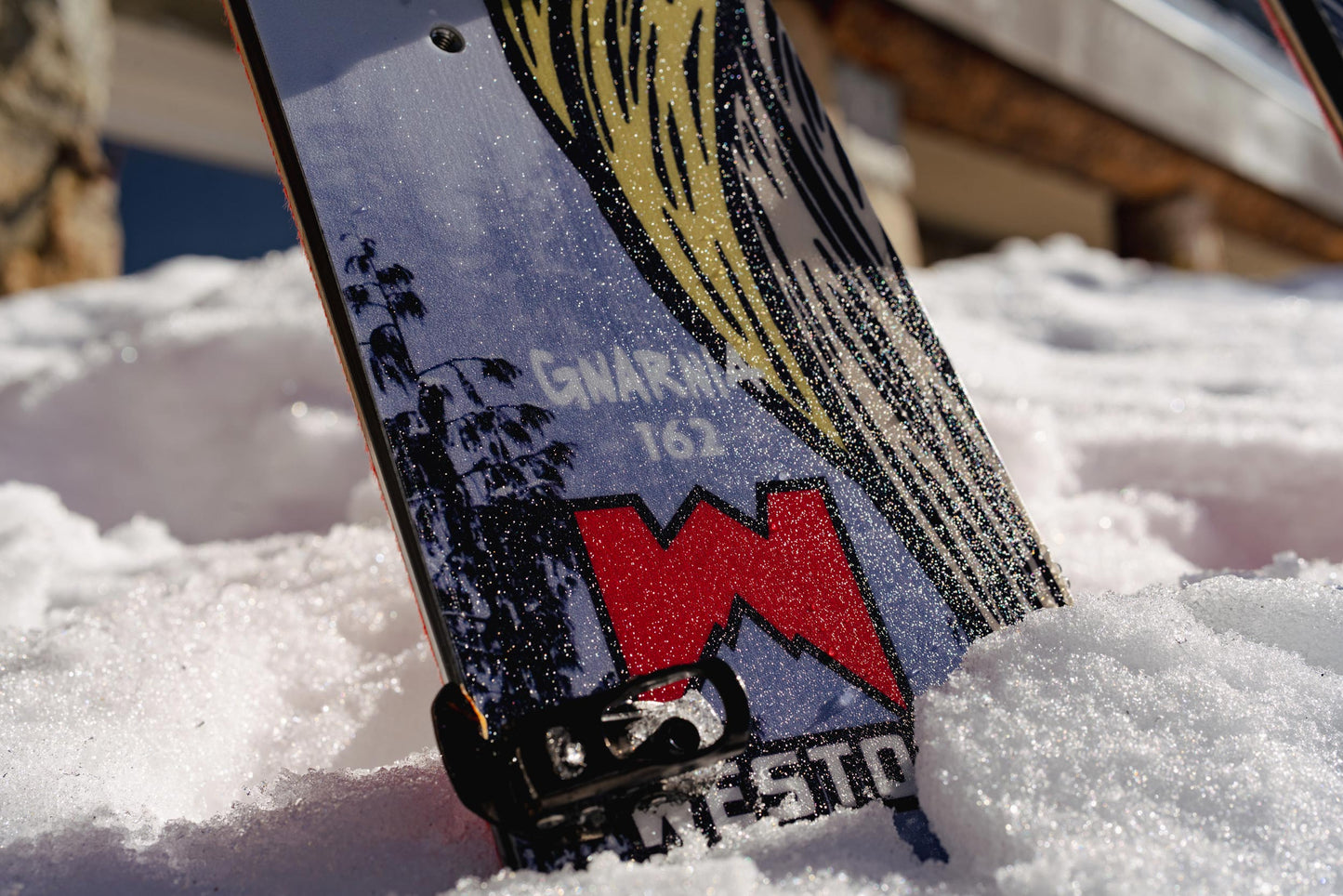 Close-up of the Weston Gnarnia Splitboard with a mountain graphic in the snow