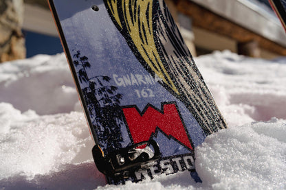 Close-up of the Weston Gnarnia Splitboard with a mountain graphic in the snow
